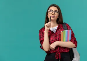 moça pensativa, direcionando uma caneta ao próprio rosto